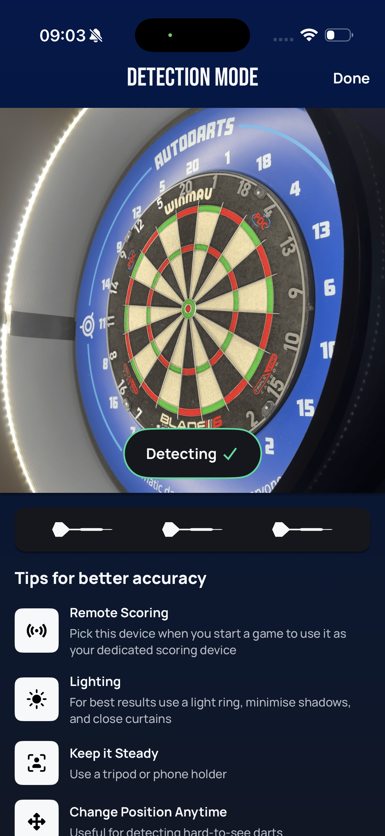 Lens Detection mode screen showing the live dartboard camera view with a green Detecting status, a row of three dart icons, and tips for better accuracy